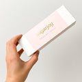 Hand holding a box of sugarjoy Swedish candy against a light gray background