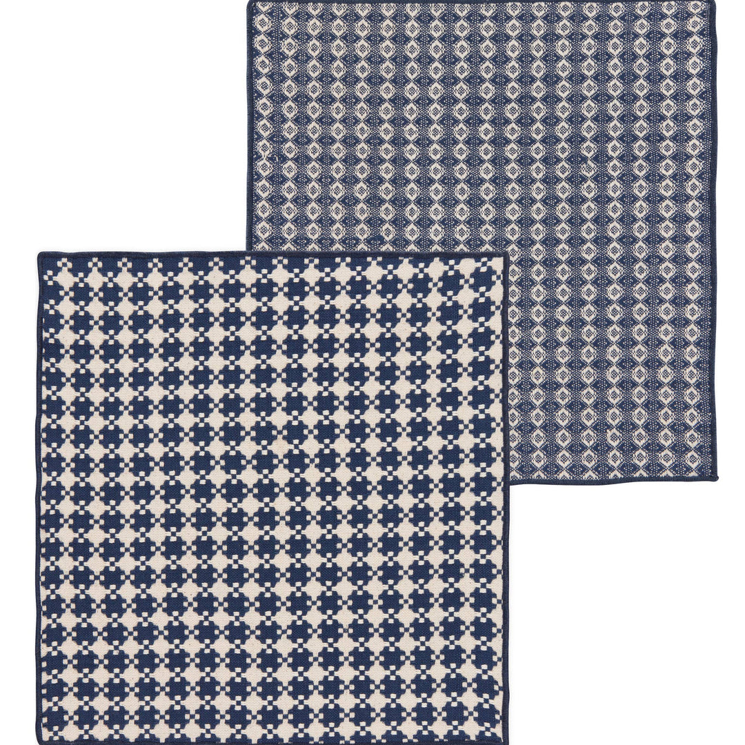 Two square woven fabric pieces with geometric patterns, shown overlapping on a plain white background. One has a navy and off-white houndstooth-like pattern, and the other has a navy and off-white diamond lattice pattern.