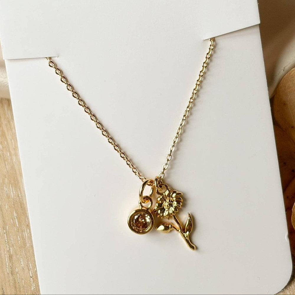 Gold necklace on a 'agaveh girl' branded card with dried flowers in the background