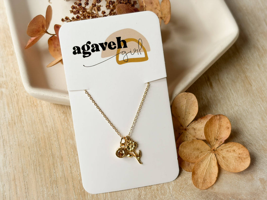 Gold necklace on a 'agaveh girl' branded card with dried flowers in the background