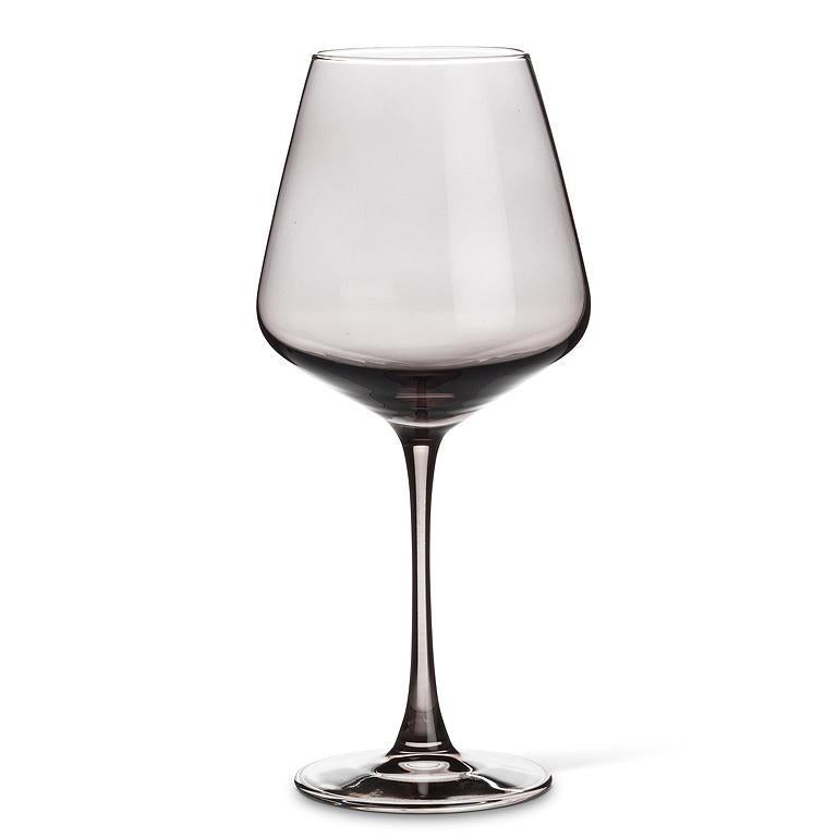 Wine glass and bottle on a kitchen counter with marble backsplash