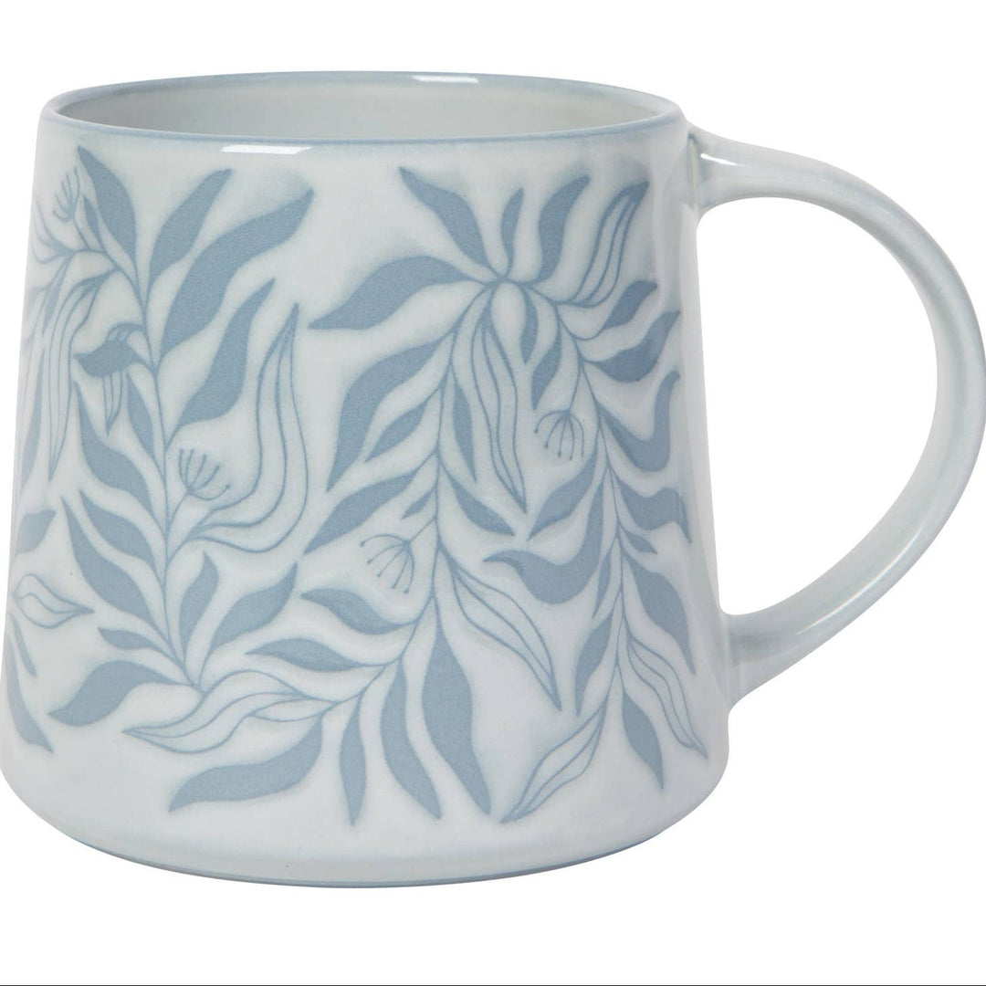 White mug with blue leaf pattern on a white background