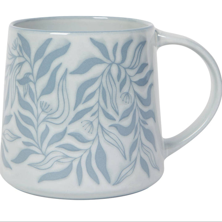 White mug with blue leaf pattern on a white background
