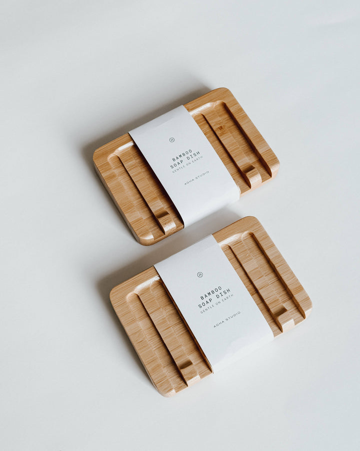 Two wooden soap dishes with white labels on a light gray background
