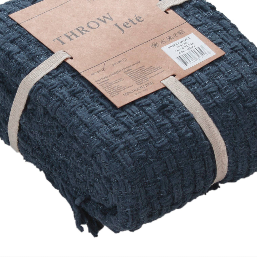 Folded navy blue throw blanket with a label on a white background