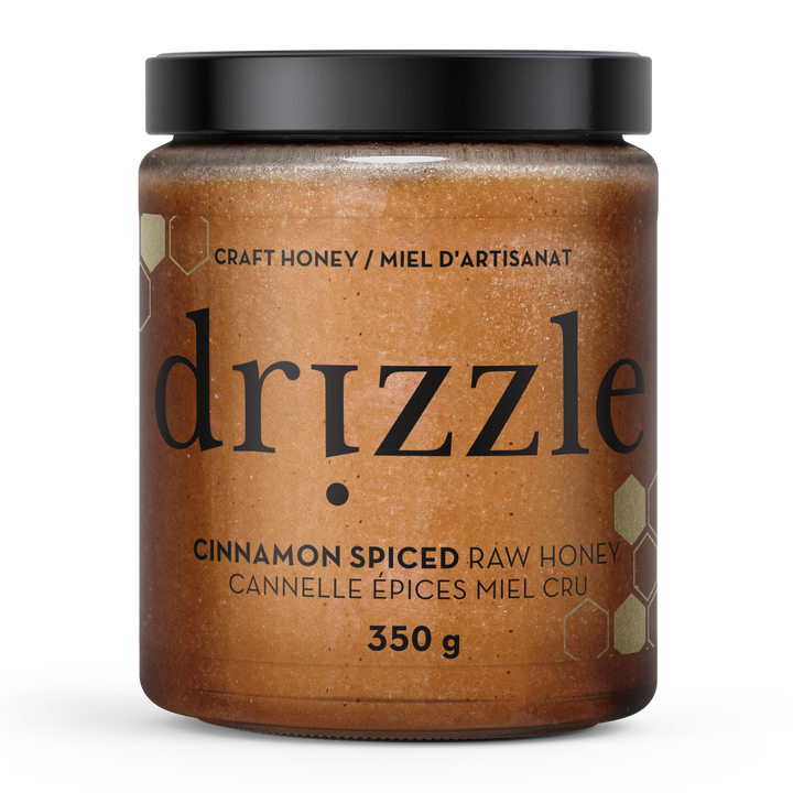 Jar of drizzle cinnamon spiced raw honey on a white background