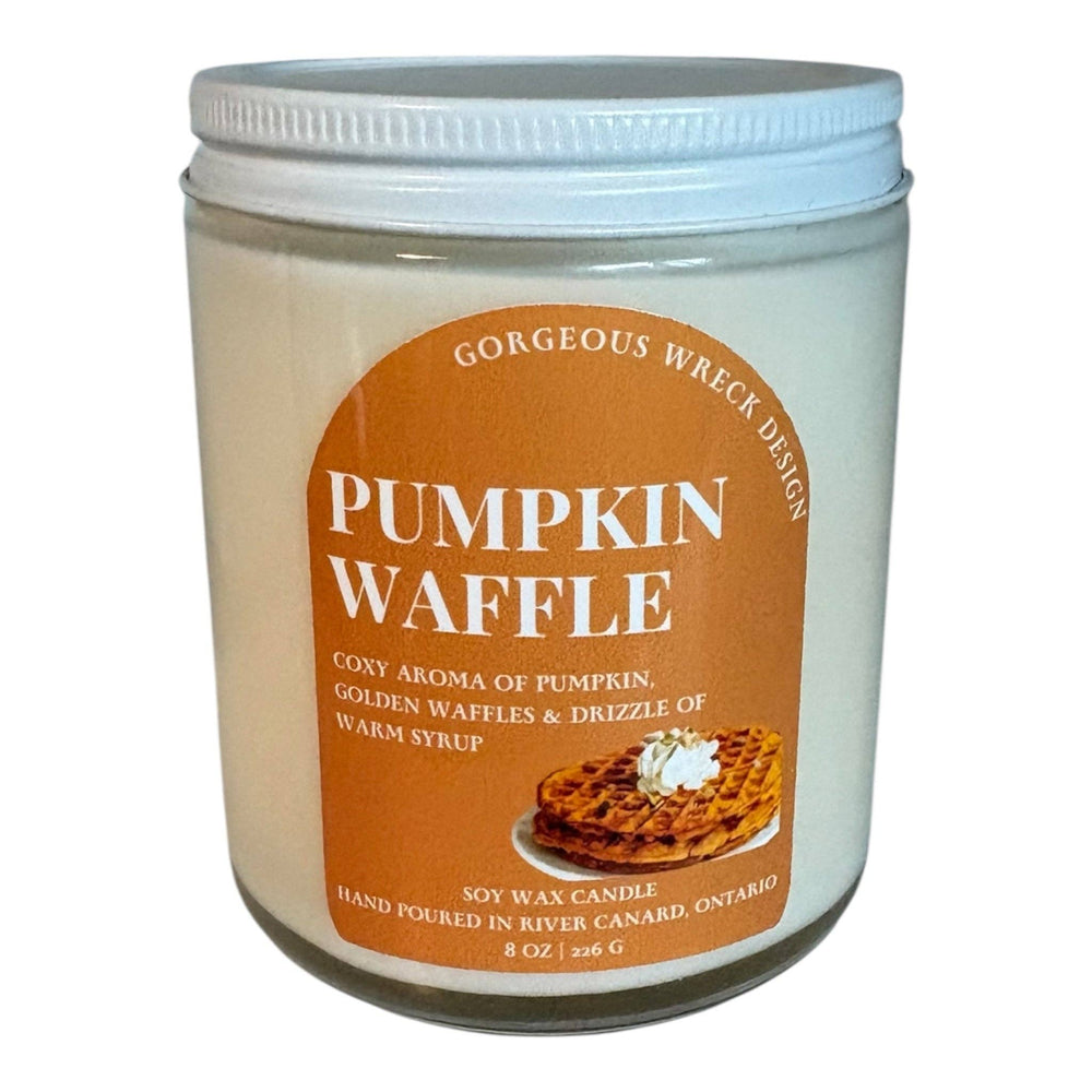 A 8 oz soy wax candle in a clear glass jar with a white lid, featuring a brown label that reads 'Pumpkin Waffle' with an image of a waffle topped with whipped cream.