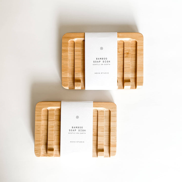 Two bamboo soap dishes with white labels on a light background