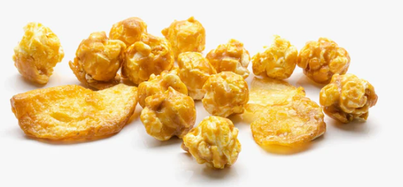 A pile of golden-yellow popcorn and dried fruit slices on a plain white background.