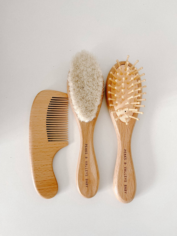 Set of three wooden hairbrushes on a light gray background