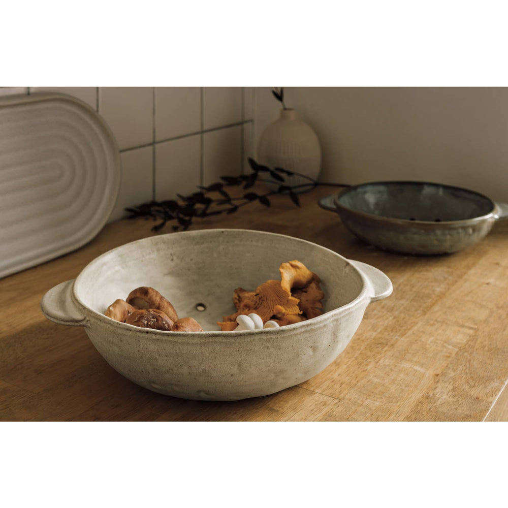 Ceramic bowl with dog toys on a wooden surface