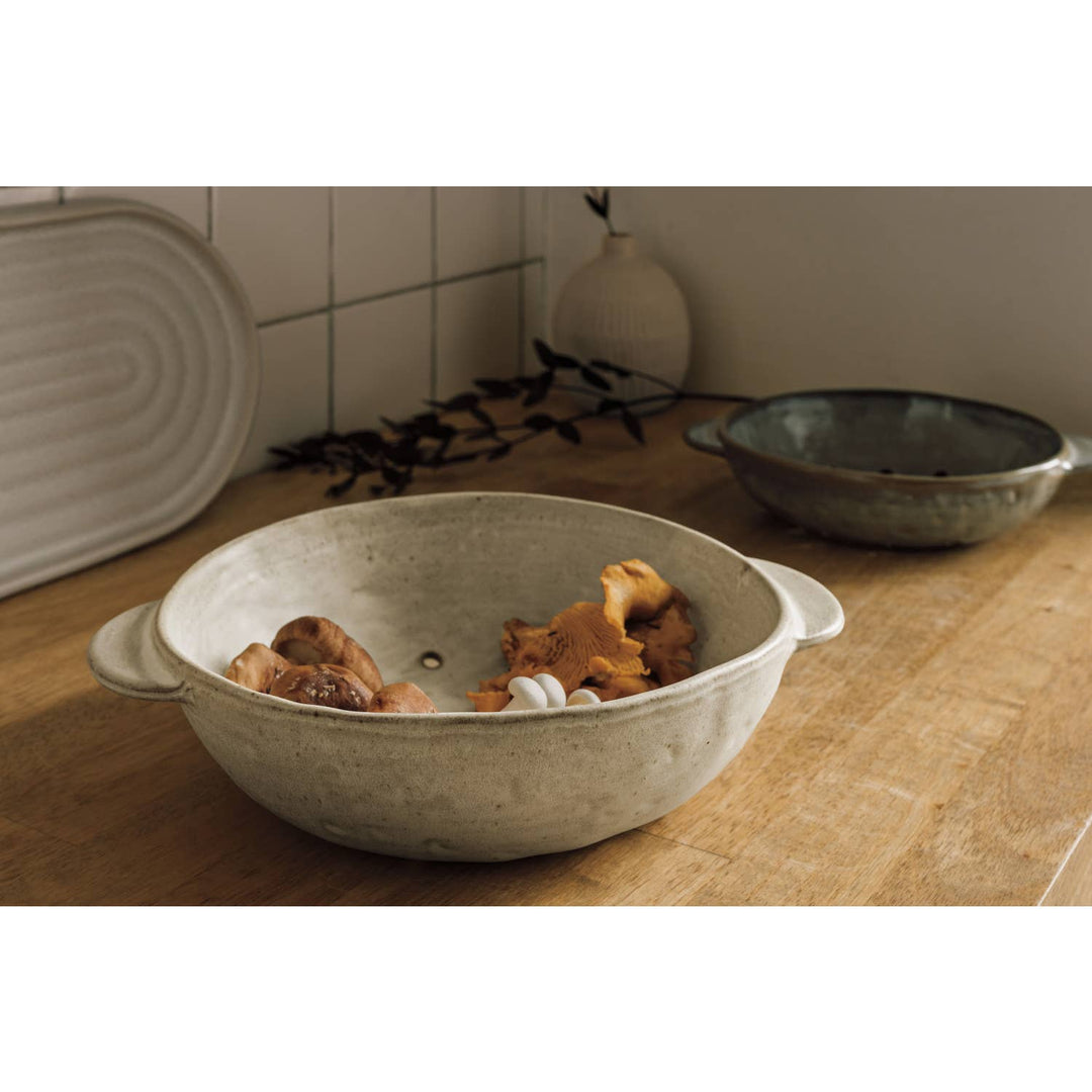 Ceramic bowl with dog toys on a wooden surface