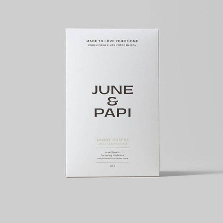 A minimalist white product box standing upright on a light gray background. The box features the brand name &