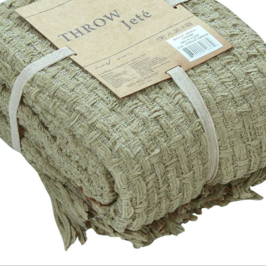 A folded woven throw blanket in a natural beige jute material, wrapped with a paper band label that reads 'JANVILLE THROW Jete'.