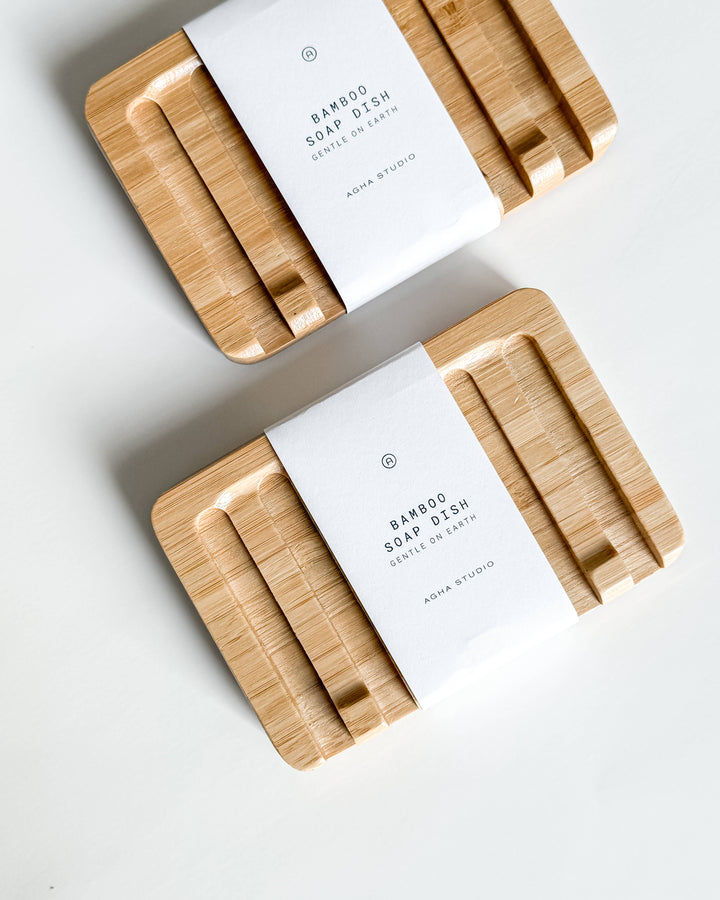Two bamboo soap dishes with white labels on a light gray background