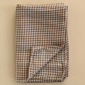 Folded brown and white checkered fabric on a beige background