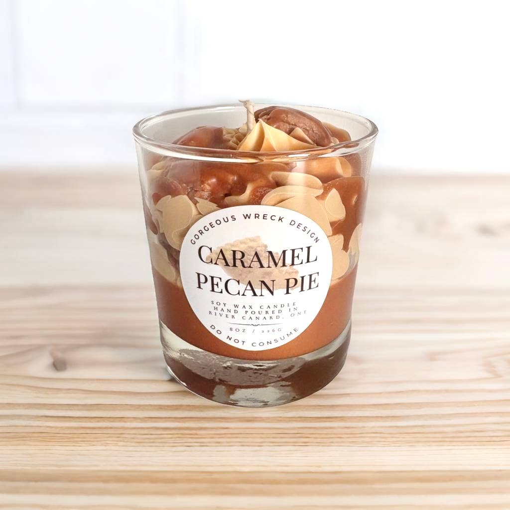 Caramel pecan pie candle in a glass jar on a wooden surface