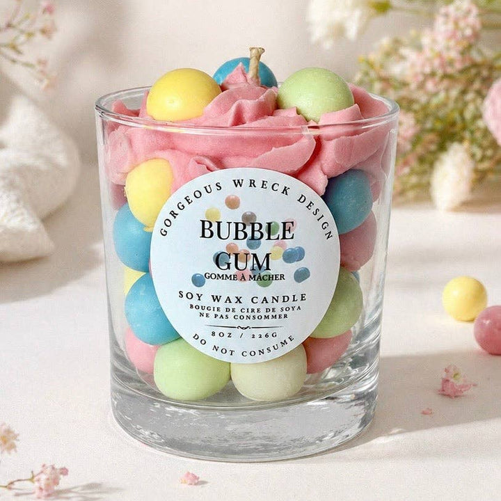 Bubble gum-themed candle with colorful candies and a visible brand label on a soft background.