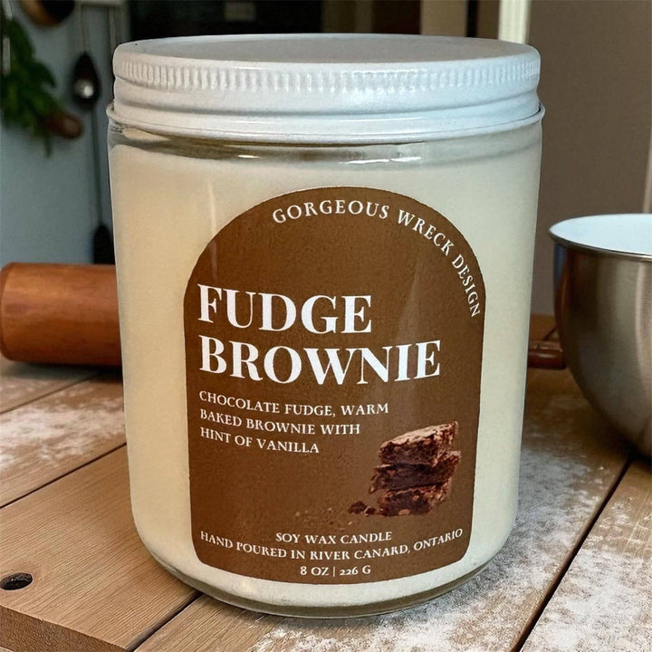 A 8 oz soy wax candle in a clear glass jar with a white lid, featuring a brown label that reads &