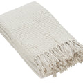 Beige woven throw blanket with fringes on a white background