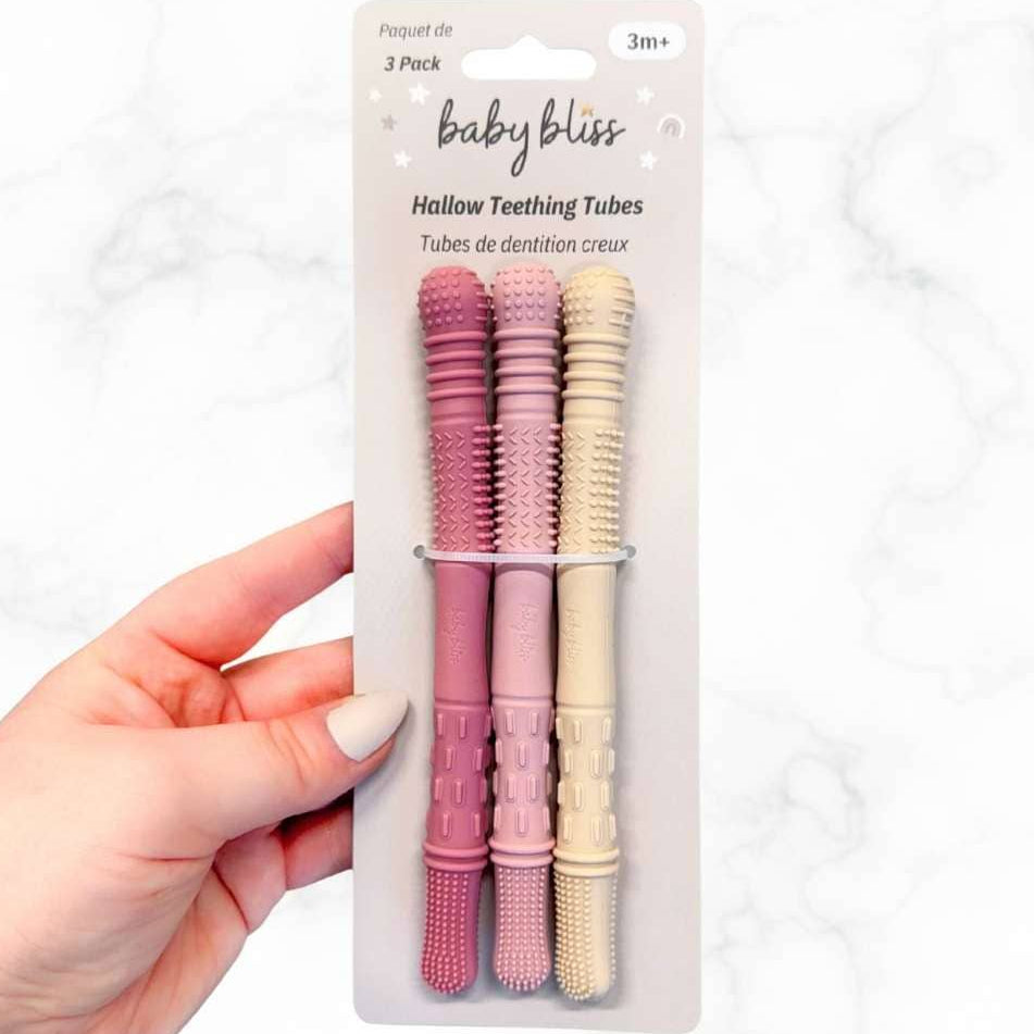Hand holding a package of baby teething tubes with &