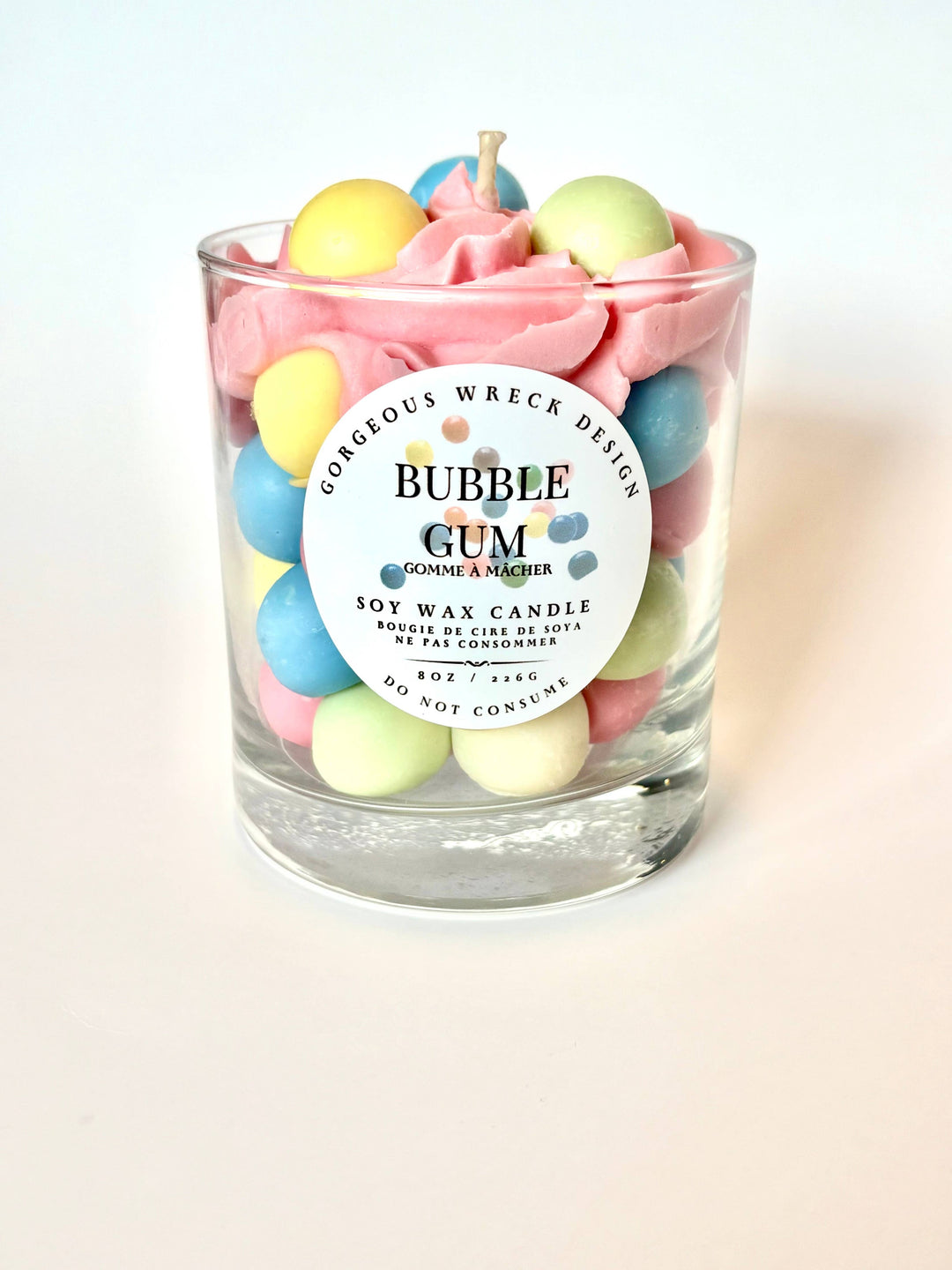 Bubble gum-themed candle with colorful gumball decorations on a light background