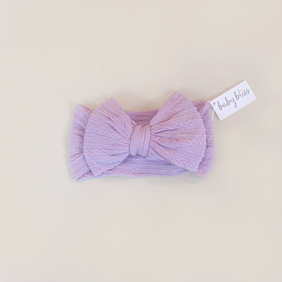 Purple headband with a bow on a beige background