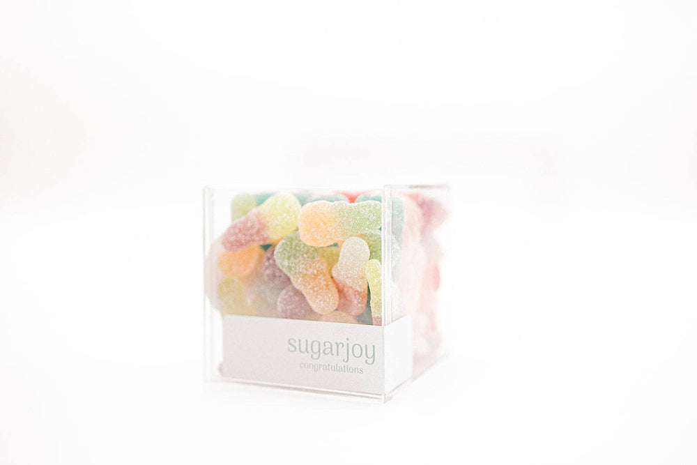 Clear cube container filled with colorful gummy bears labeled 'sugarjoy' on a white background