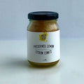 Jar of preserved lemon confit with a black lid on a white background