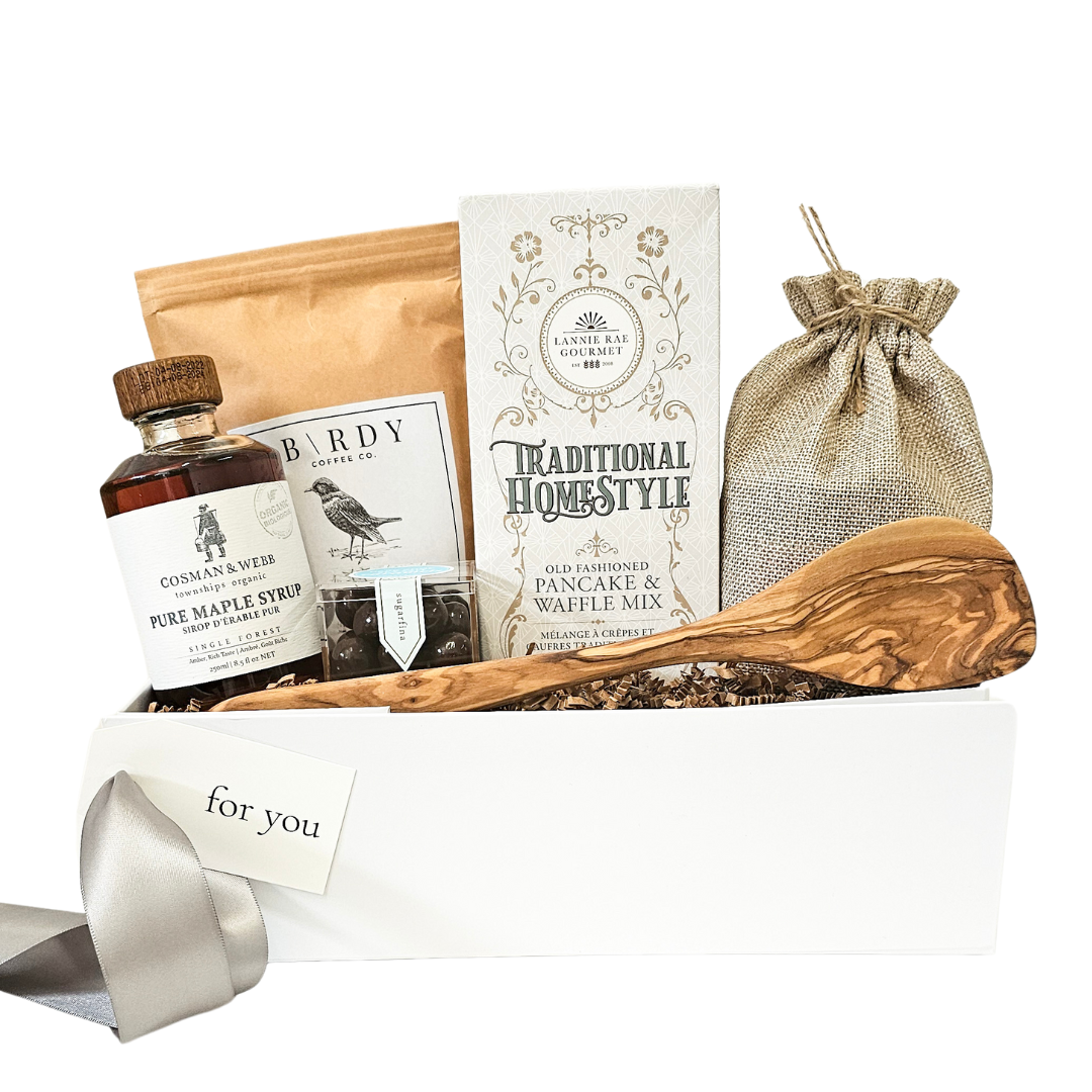 Elegant Gourmet Brunch Gift Box containing high-quality maple syrup, organic pancake and waffle mix, rich artisan coffee, and a rustic wooden spoon, all beautifully arranged in a chic white gift box with a sleek silver ribbon and a personalized 'for you' card, perfect for a luxurious gift basket option.