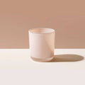 Light pink ceramic tumbler on a beige background