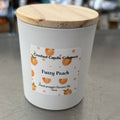 Crushed Candle Company fuzzy peach candle with a creamy, plush texture and peach scent, shown in a clear glass container.