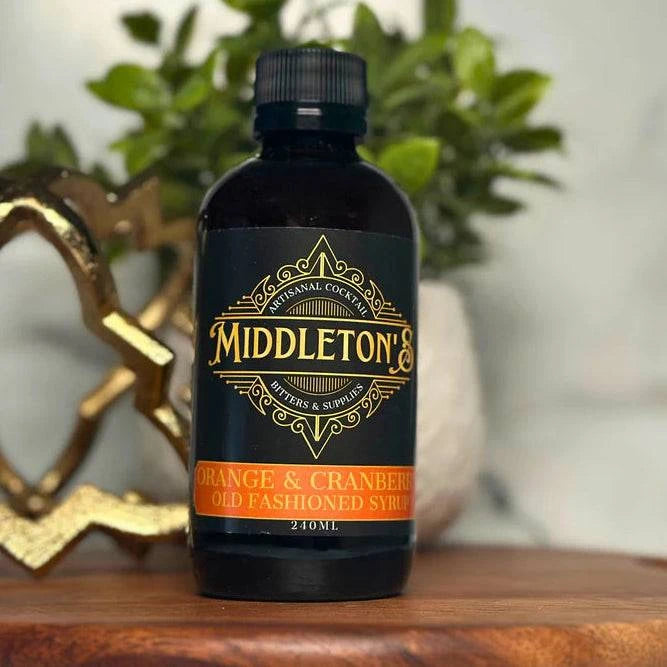 Bottle of Middleton's Orange & Cranberry Syrup on a wooden surface with a blurred background