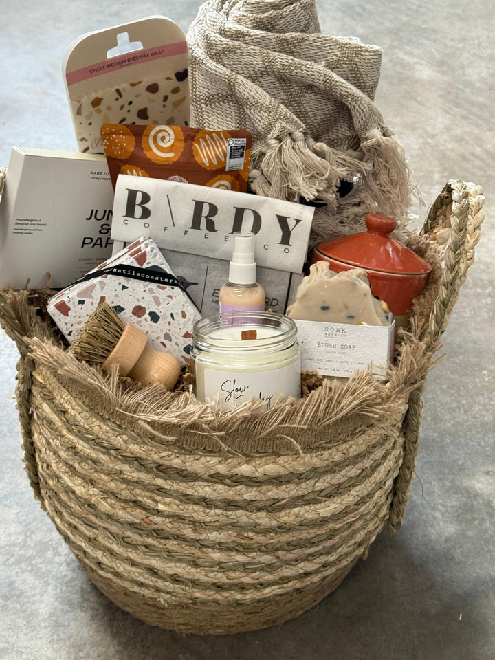 Woven basket filled with various items including a bottle labeled &