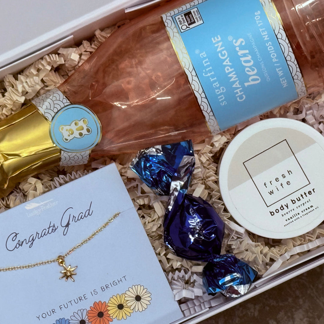 Gift box with champagne, candy, necklace, and body butter