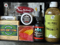 Collection of grooming and lifestyle products including a bottle, cologne, and other items on a gray surface.