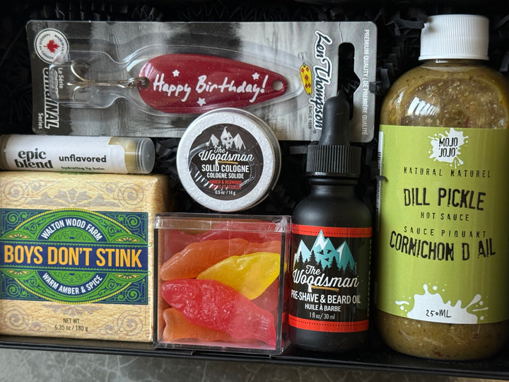Collection of grooming and lifestyle products including a bottle, cologne, and other items on a gray surface.