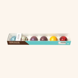 A boxed set of five decorative chocolate-covered eggs in a clear plastic tray with a teal and brown label, shown on a plain light beige background.
