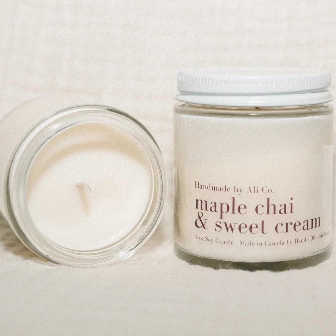 Two candles, one lit and one unlit, on a textured surface with &