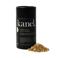 Black seasoning container labeled 'kanel' with a pile of herbs on a white background
