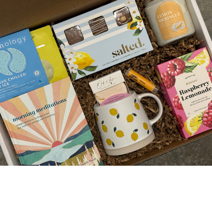 Gift box with a mug, books, and snacks on a white background