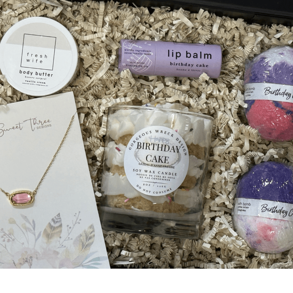 Gift set with candle, lip balm, bath bombs, and body butter in a box.