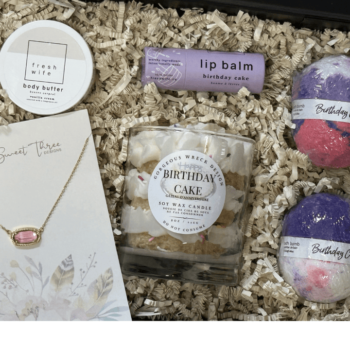 Gift set with candle, lip balm, bath bombs, and body butter in a box.