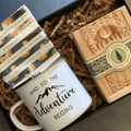 Box Builder "The Adventure Begins" gift box with colorful wrapping, ribbon, and custom packaging for special occasions.