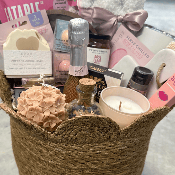 Gift basket with various items including candles and soaps on a light background