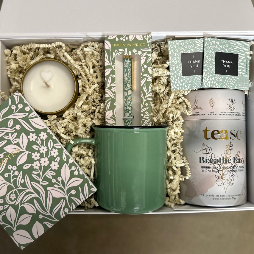 Gift box with tea, mug, candle, notebook and pen