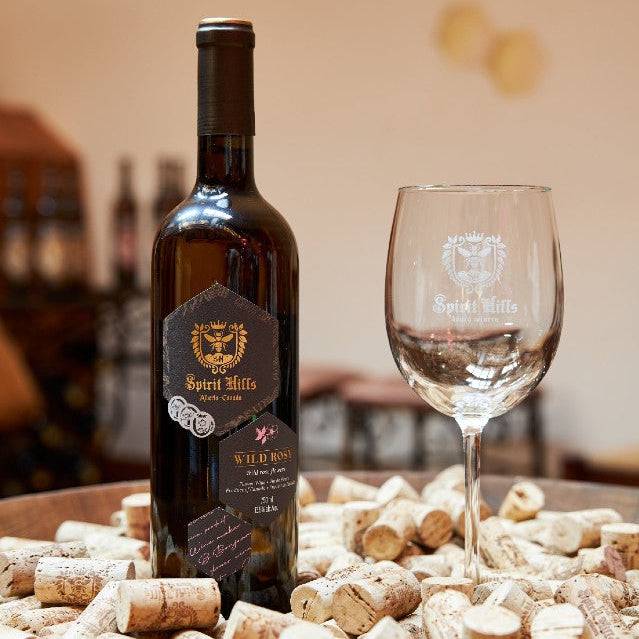 Wine bottle and glass on a table with wine corks, blurred background
