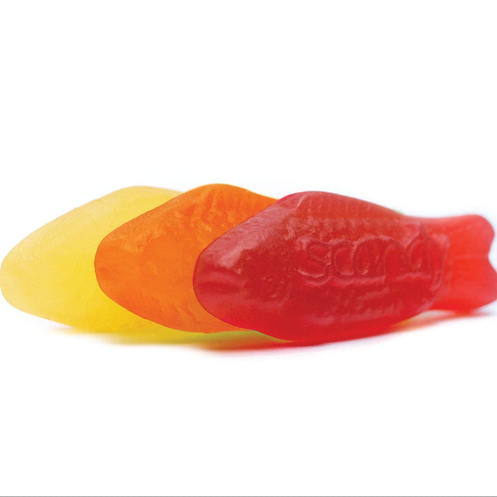 Three gummy fish-shaped candies in red, orange, and yellow on a white background