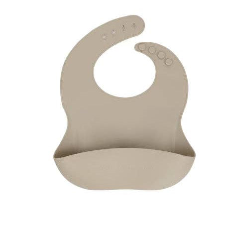 A minimalist, curved silicone baby bib in a solid taupe-beige color, featuring a wide bottom lip for containment and small ventilation holes near the top, shown on a plain white background.