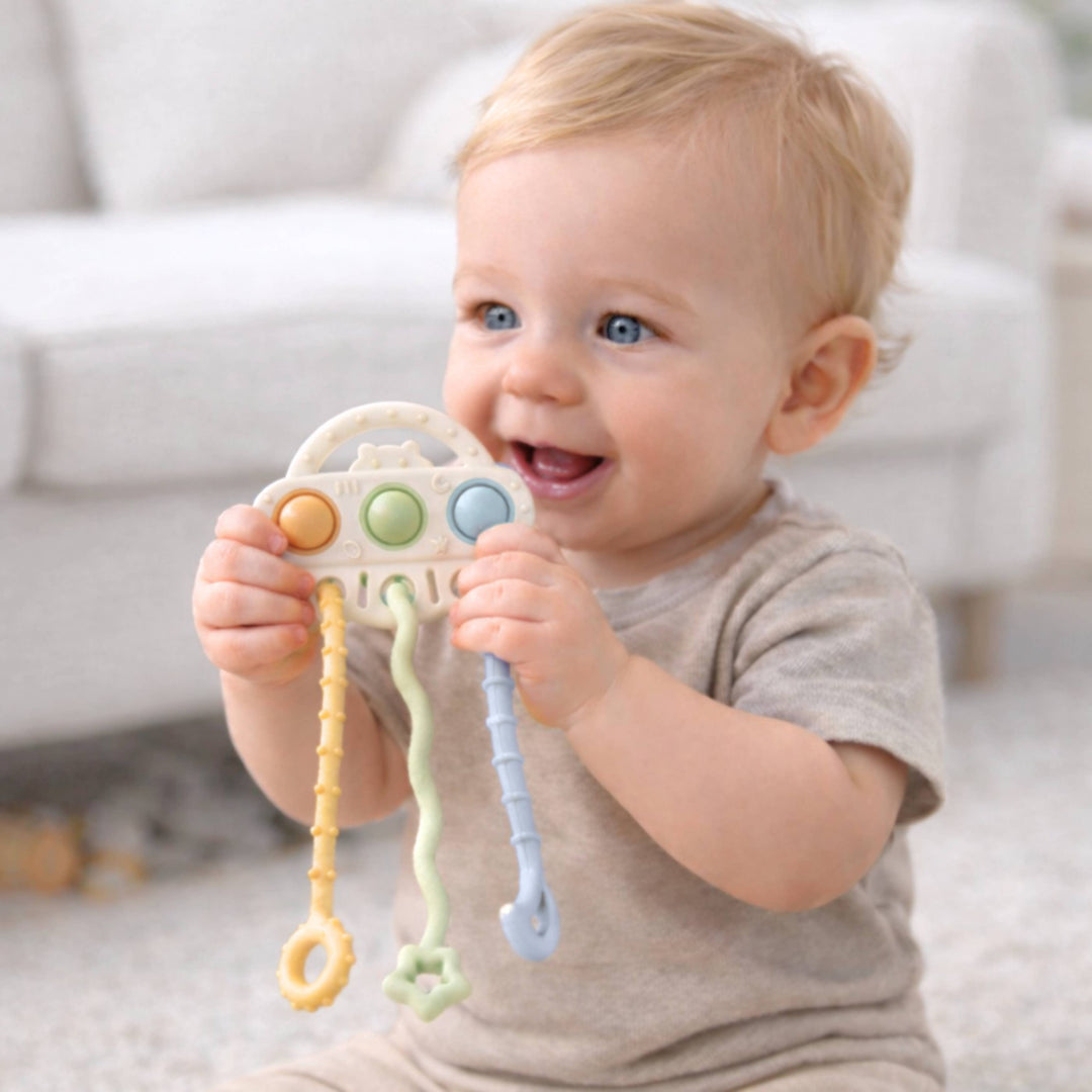 Baby holding a colorful toy with a blurred background